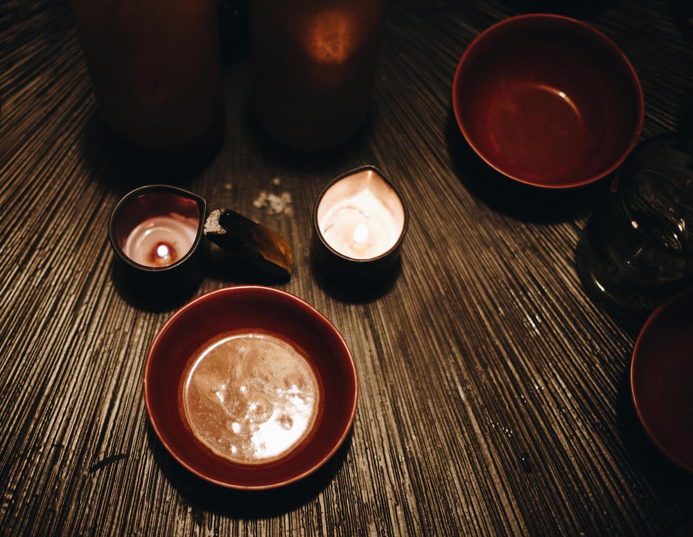 Bowl of cacao with candles on a bamboo mat