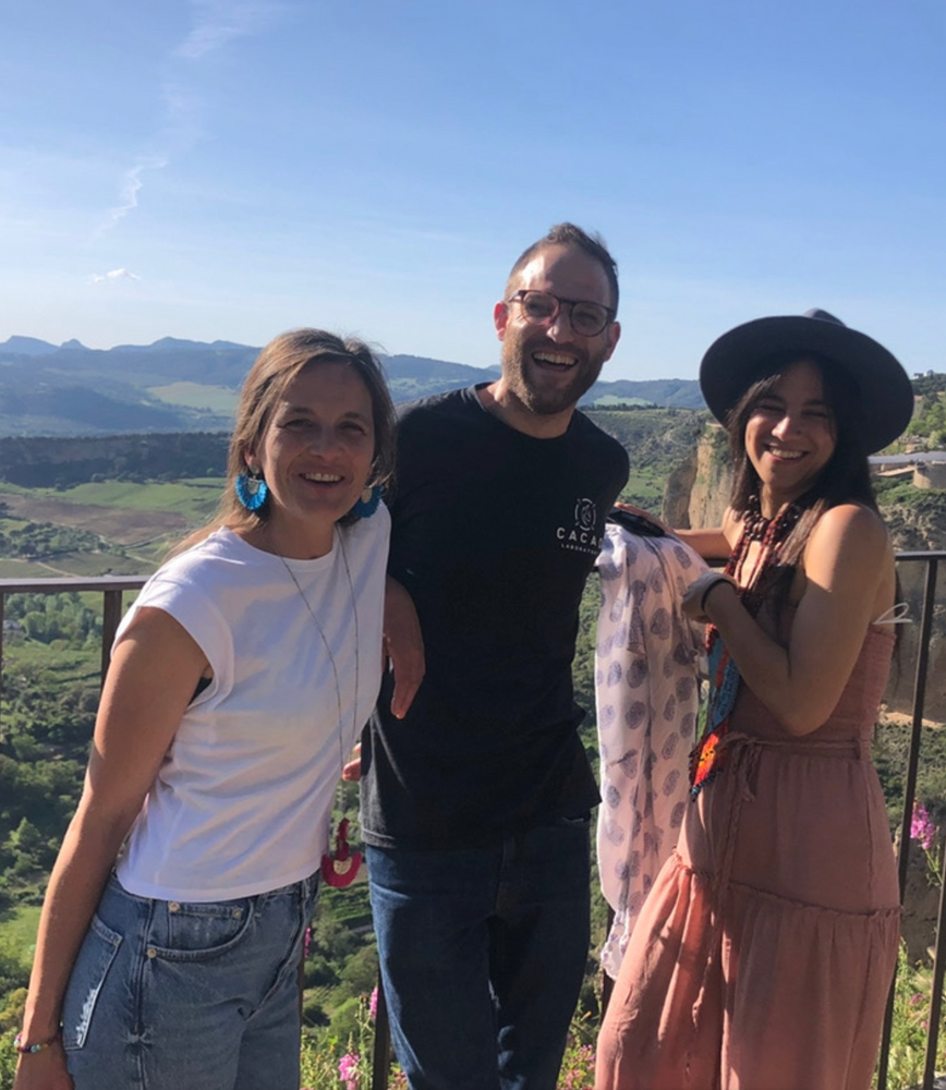 Three people smiling on a cliff