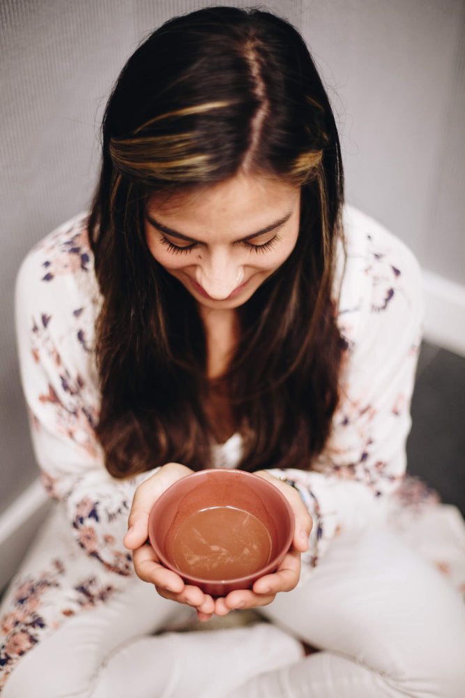 woman smiling at a bowl of cacao